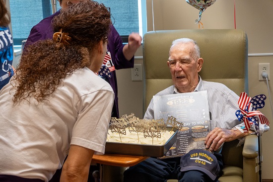 Gerden Riemenschneider receives a cake for his 102nd birthday, part of a surprise celebration thrown by his care team.