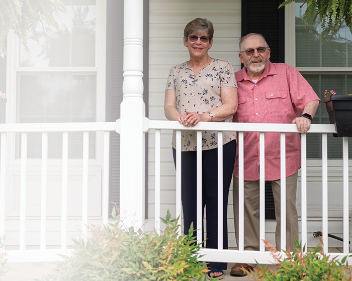 Cathy and her husband standing on the porch