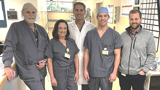 Five neurosurgery team members smiling